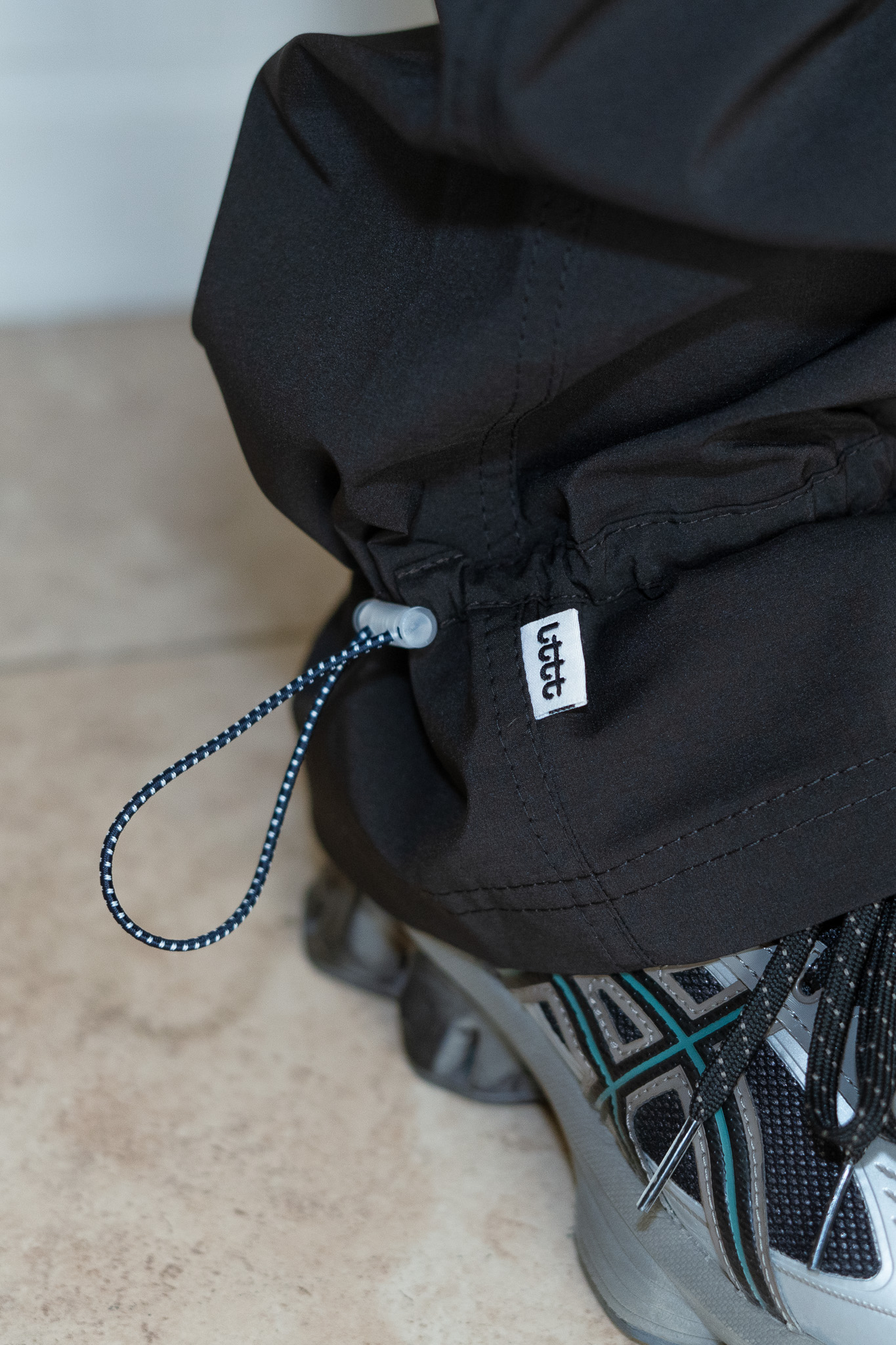 LTTT Bungee Pants V.3 - Black --These pants were part of the aforementioned birthday celebration. I had seen these pants on their site a while ago when they first dropped and always really liked the plaid pocket detail. Initially, I wasn't super crazy about the bungee cinching detail, but that has since become my favorite part about these pants.  --It took a little longer for this pair to arrive than it did for the ASICS pair because they originally sent me the black ASICS pants, which I desperately wanted to keep. LTTT's customer service was very nice and personable - it felt quite pleasant coordinating the exchange. They even sent me a super cool tote to make up for the mixup. Much love to Kyle Chen. I have had these pants since August 2025. 